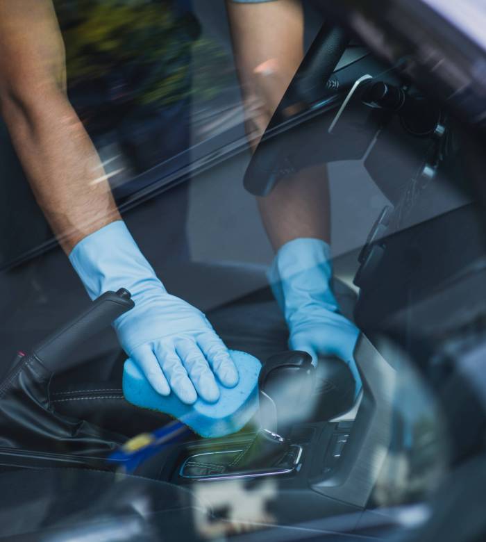 cropped view of car cleaner wiping car interior with sponge cropped view of car cleaner wiping car interior with sponge